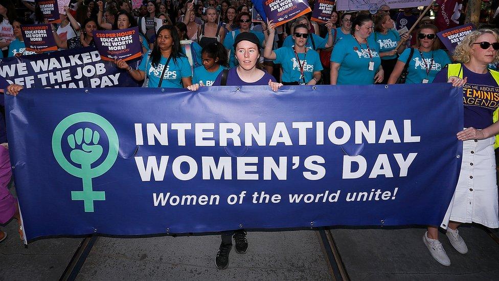 A protest with a banner held saying 'International Women's Day'