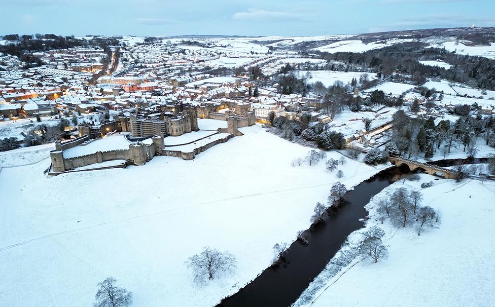 Snow covered fields surround Alnwick Castle in Northumberland