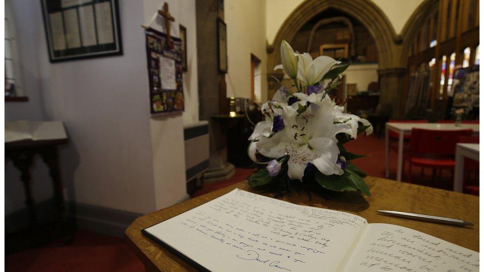 Messages of condolence written by Prime Minister David Cameron and Labour Party leader Jeremy Corbyn in a book of remembrance for Jo Cox in St Peter"s church in Birstall, West Yorkshire