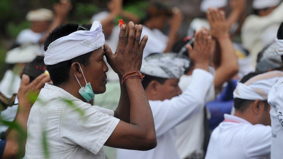 Balinese Hindus take part in a ceremony, where they pray near Mount Agung in hope of preventing a volcanic eruption, in Muntig village