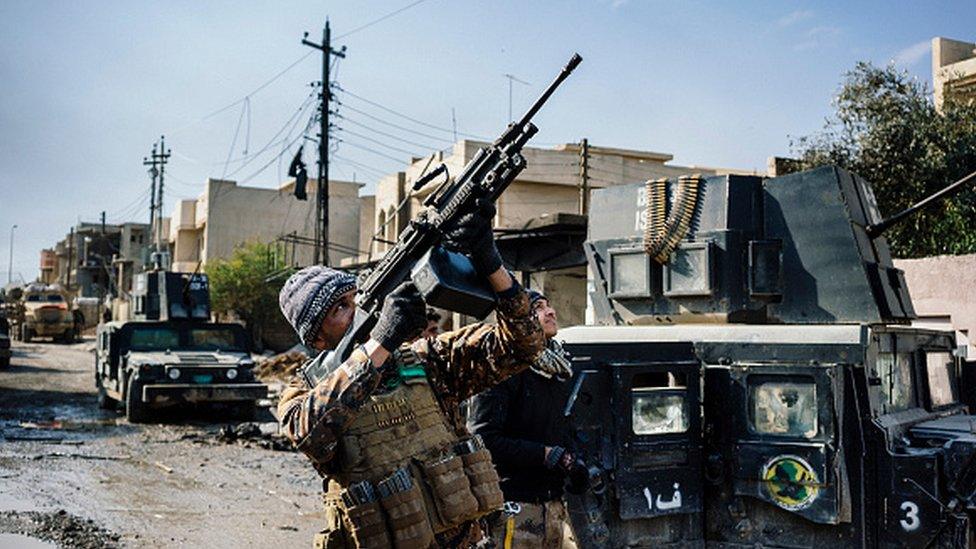 An Iraqi special forces member shoots at a drone flown by Islamic State group jihadists in 2017