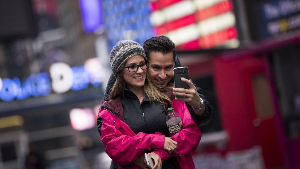 A couple takes a photograph of themselves in Times Square, March 1, 2017 in New York City.