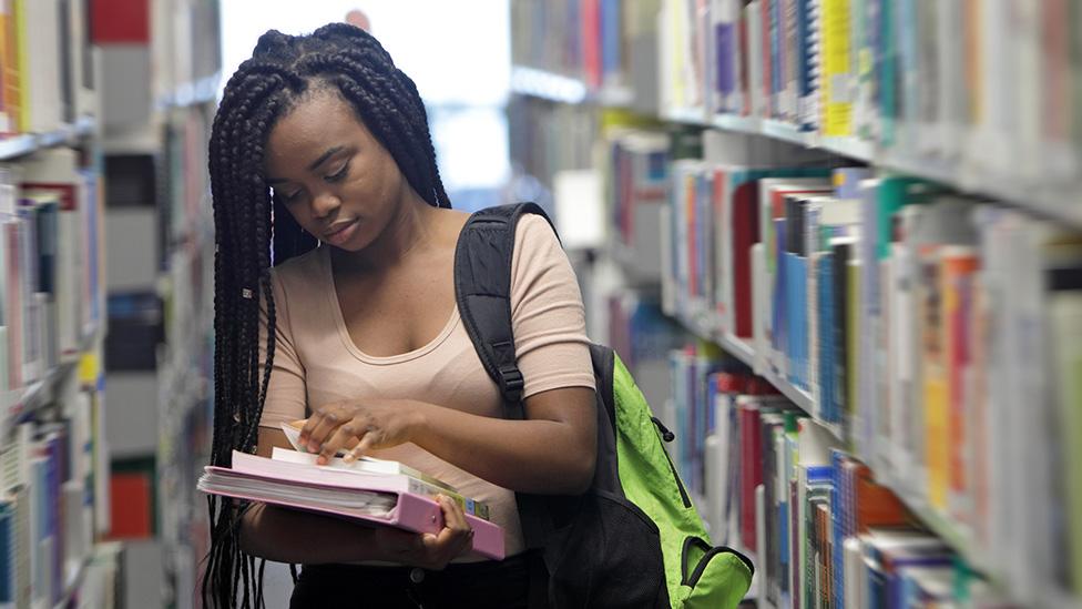 student in library with books