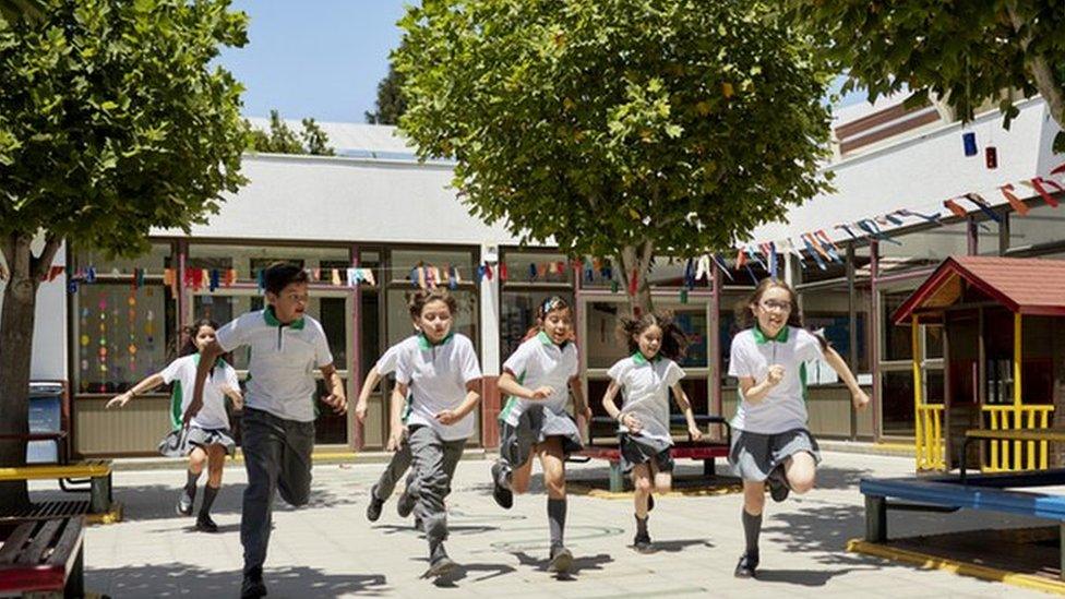 kids running in playground with trees