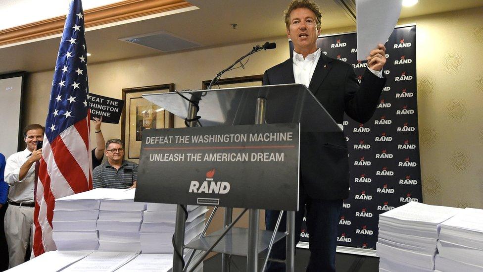 Kentucky Senator Rand Paul poses with US tax documents.