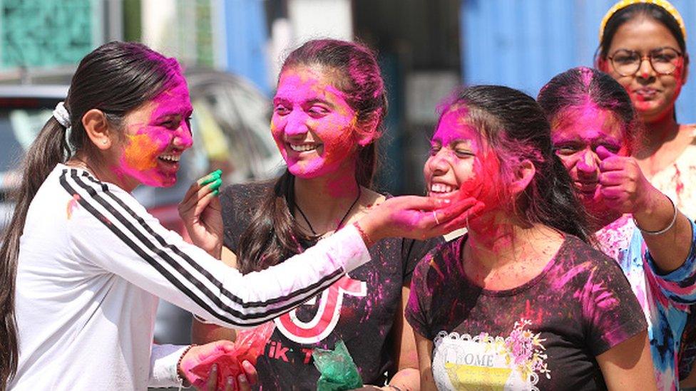 Women play with colours on the eve of Holi festival on March 17, 2022 in Bathinda, India