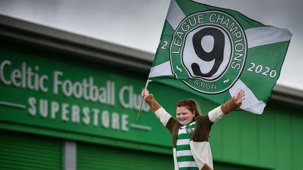 A young Celtic fan celebrates the club being named Scottish football champions