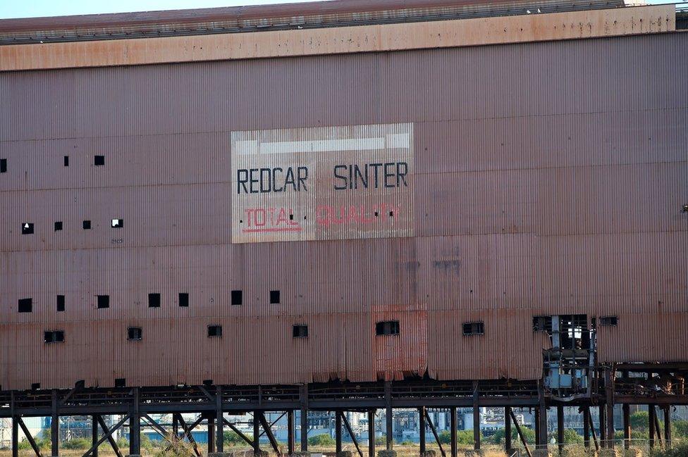 Close up of the enormous building, which has a corrugated metal shell