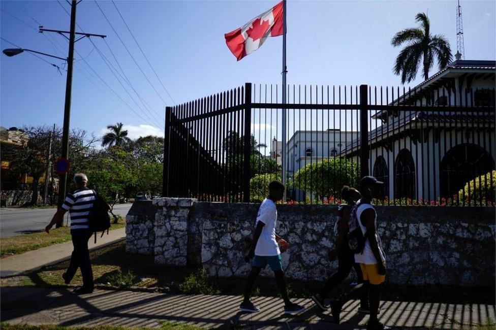 People walking past the Canadian embassy in Havana