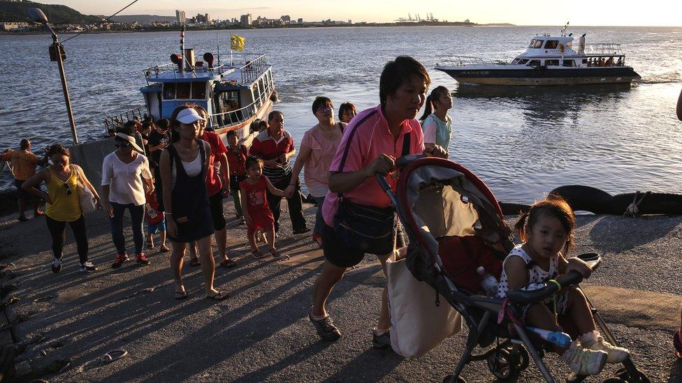 Ferry passengers disembark at the port area in New Taipei City, Taiwan, 06 July 2016