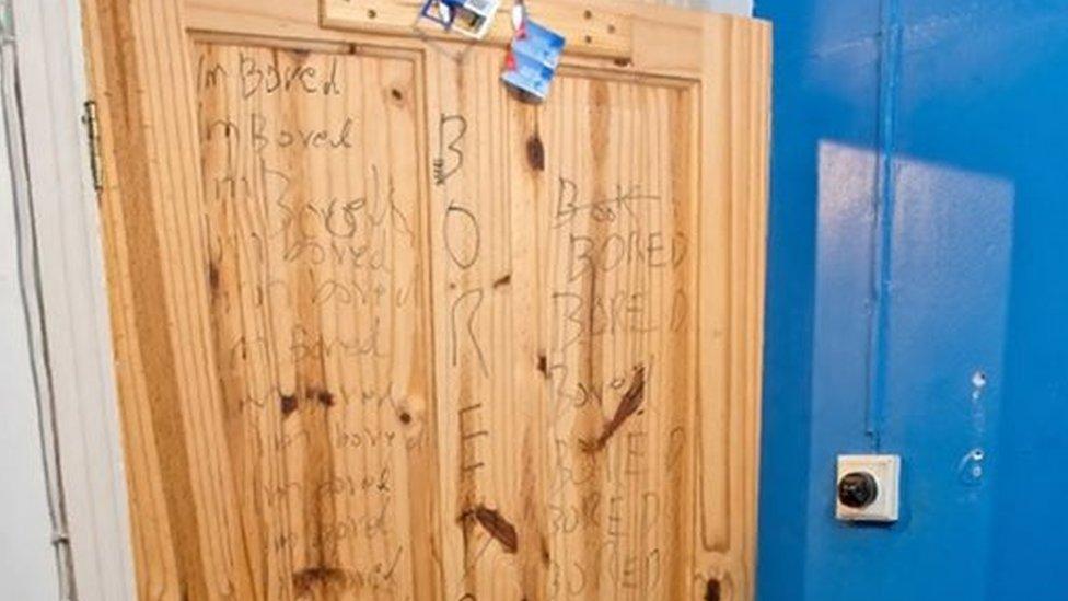 Ahmed Hassan's bedroom door with "I am bored" written on in pen