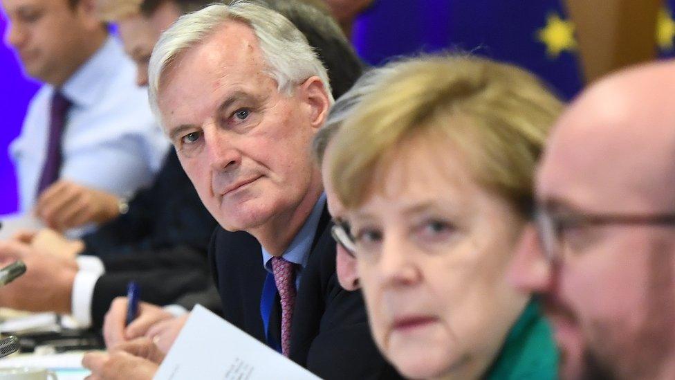 Chief Brexit negotiator Michel Barnier, centre, looks at the camera, as does German Chancellor Angela Merkel (in slightly soft focus)