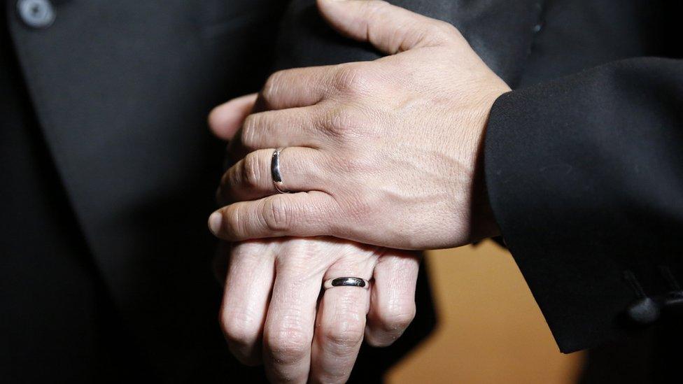 Gay couple hold each other after marrying in a same-sex wedding in Islington, London, March 2014