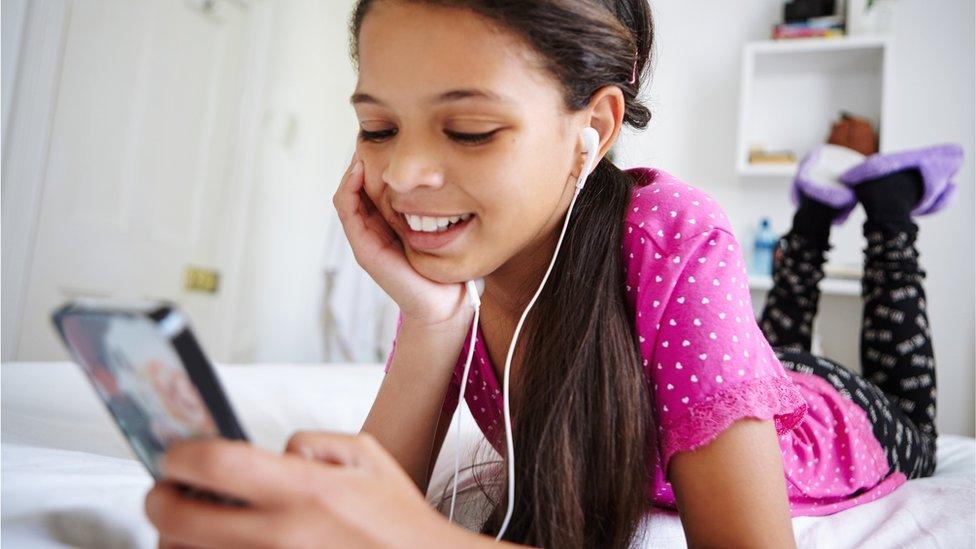 Child-listening-to-music-on-bed.