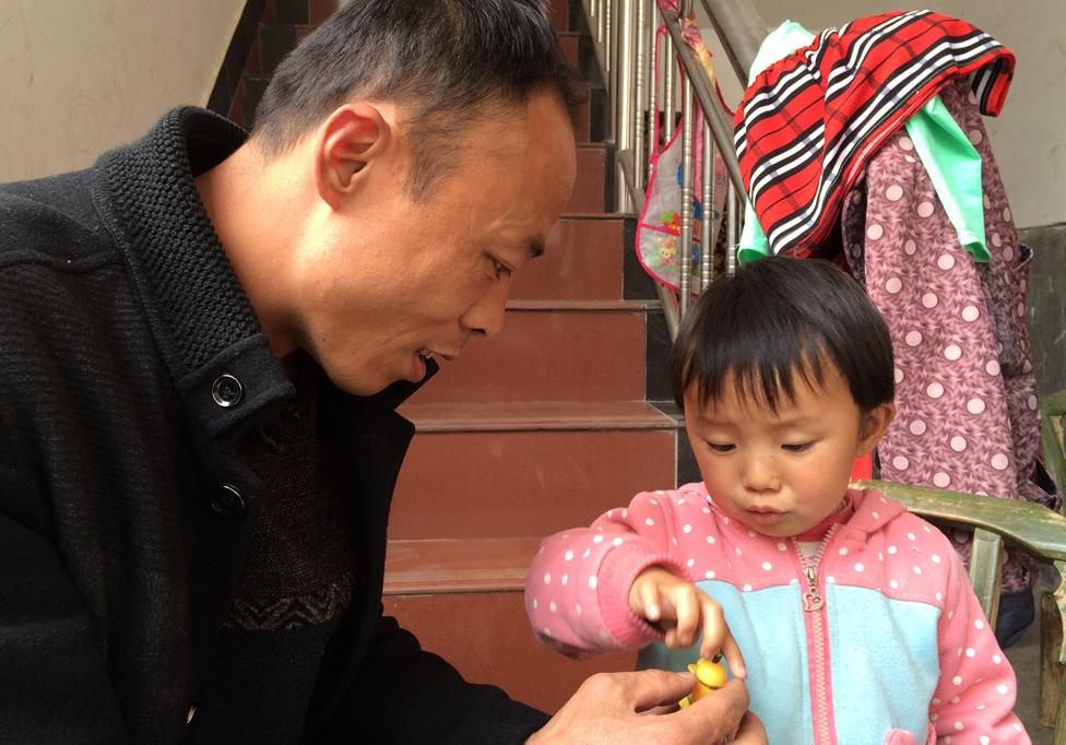 Family planning officer Li Bo plays with two-year-old Liu Siqi