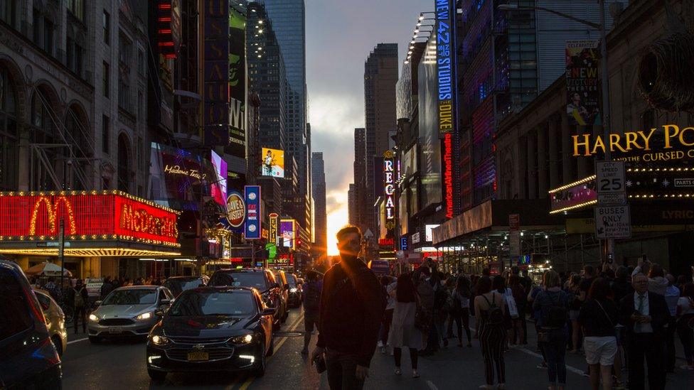 People take a look at the phenomenon known as Manhattanhenge on 42nd Street on May 30, 2018 in New York City