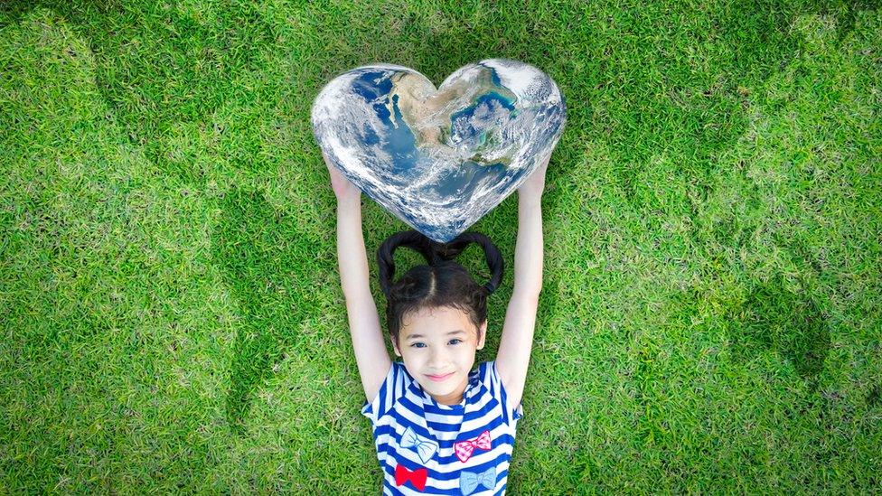 girl-holding-heart-shaped-earth