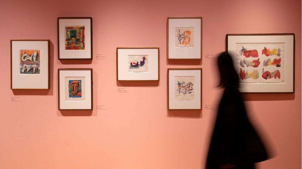 Person walking past felt tip pen drawings which form part of the new exhibition "Henry Moore: The Sixties" which opens to the public on Friday April 1 at the Henry Moore Studios and Gardens in Much Hadham, Hertfordshire