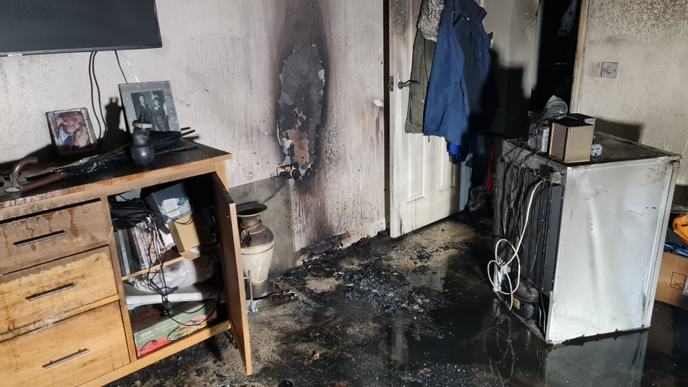 A room inside a Bedminster house, badly damaged by smoke and fire, with soot covering the walls and carpet