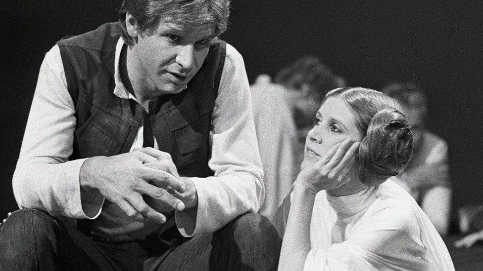 Harrison Ford talks with Carrie Fisher during a break in the filming of the CBS-TV special The Star Wars Holiday in Los Angeles on 13 Nov, 1978