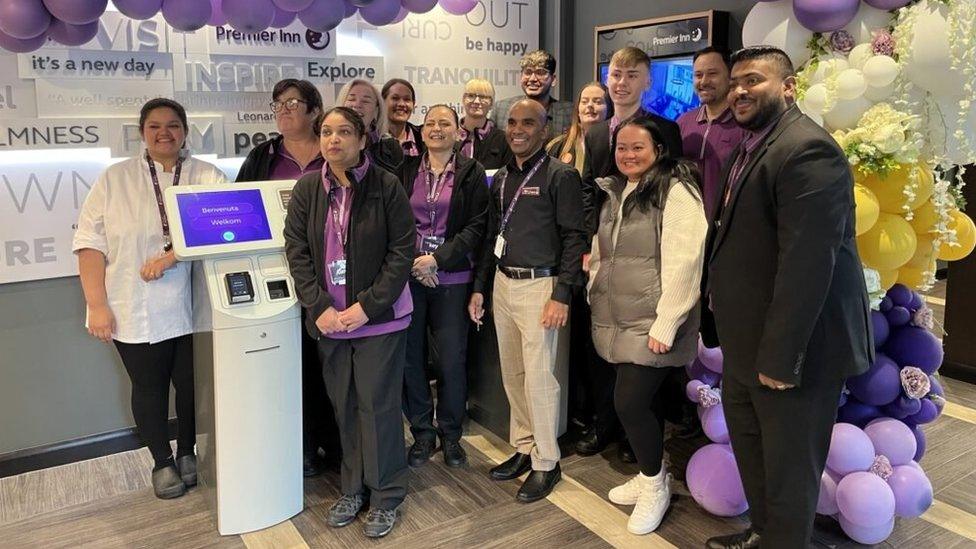 Several people smiling for a photo in the hotel's check in area