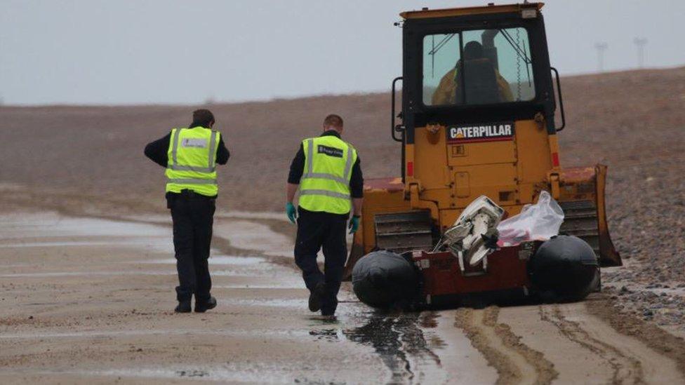 The dinghy is towed away from the scene