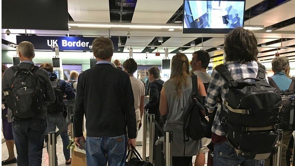 People waiting at passport control at Heathrow airport