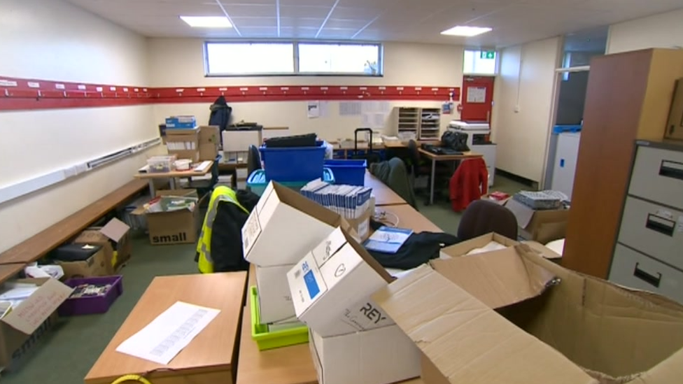 A room with boxes filled with papers and exercise books