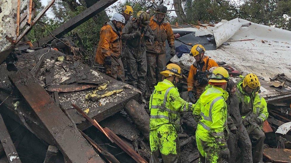 Firefighters rescue a girl after she was trapped inside a destroyed home during heavy rains in Montecito, California.