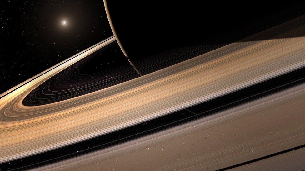 Saturn with the sun in the distance.