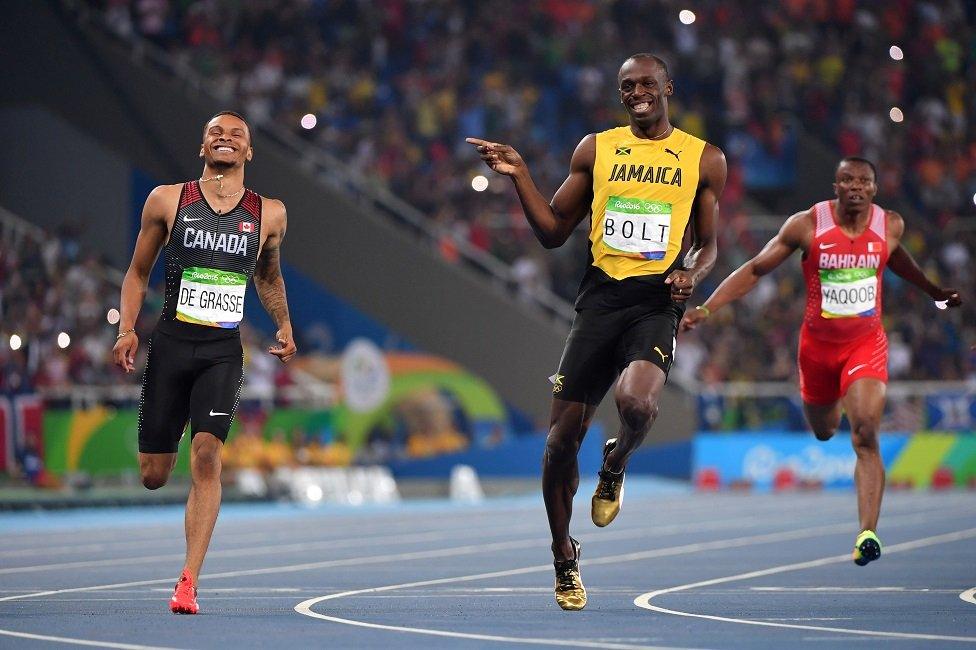 Jamaica's Usain Bolt (C) jokes with Canada's Andre De Grasse (L) after they crossed the finish line in the Men's 200m Semifinal during the athletics event at the Rio 2016 Olympic Games at the Olympic Stadium in Rio de Janeiro on 17 August, 2016