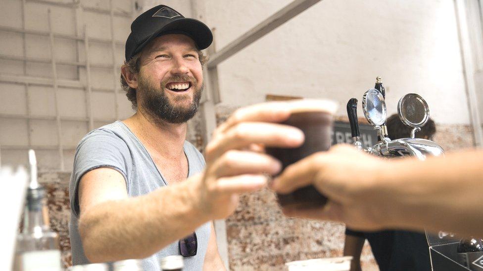 Barista hands over a coffee