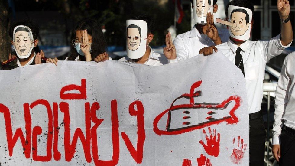 Thais student wearing a mask of a caricature of Thai Prime Minister Prayut Chan-ocha with a Pinocchio nose