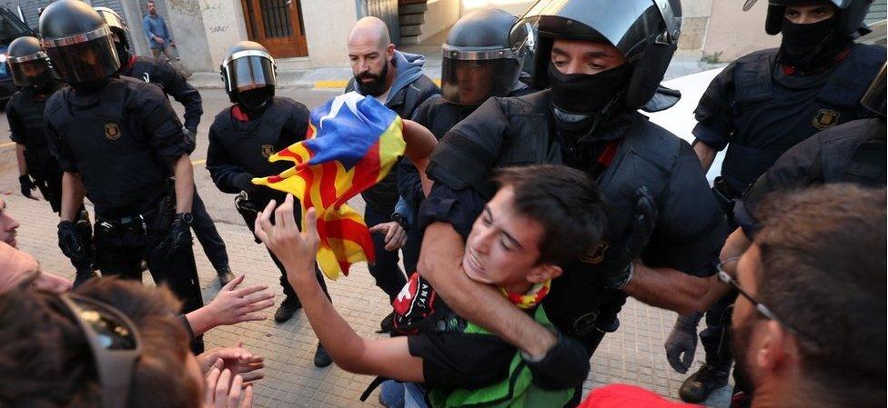 Police remove a protester outside Unipost office in Terrassa on 19 Sept