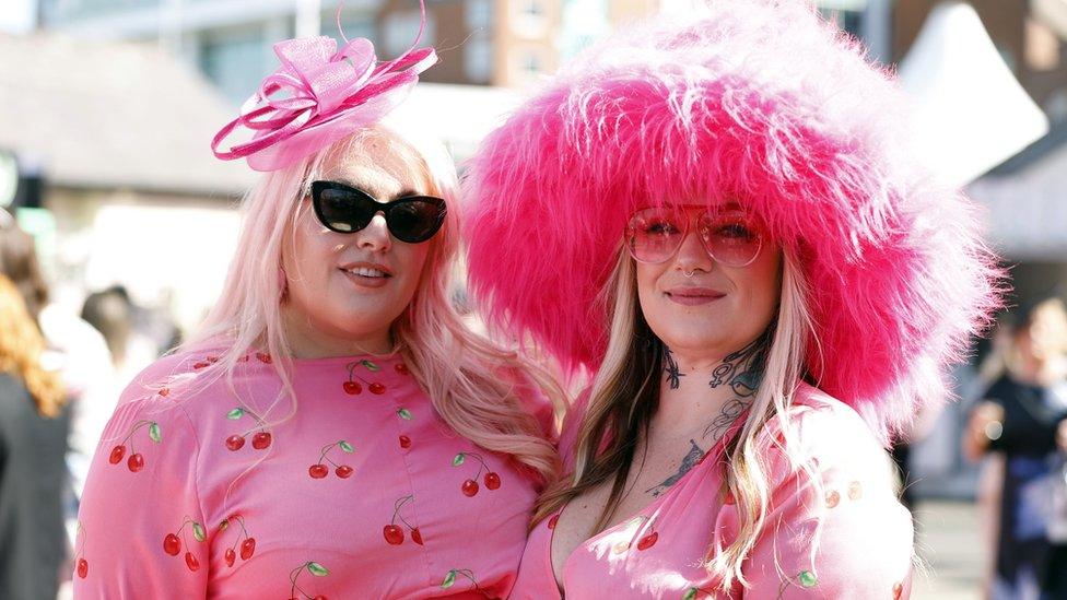 Two women pose for photos on Ladies Day at Aintree