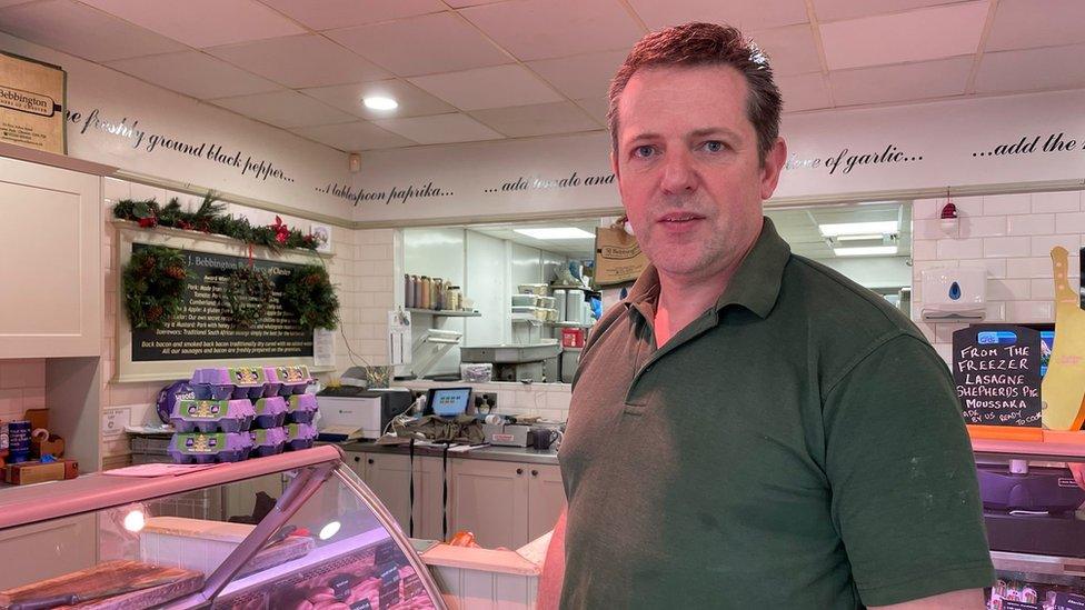 Butcher Stuart Bebbington standing in his shop with meat counters in the background