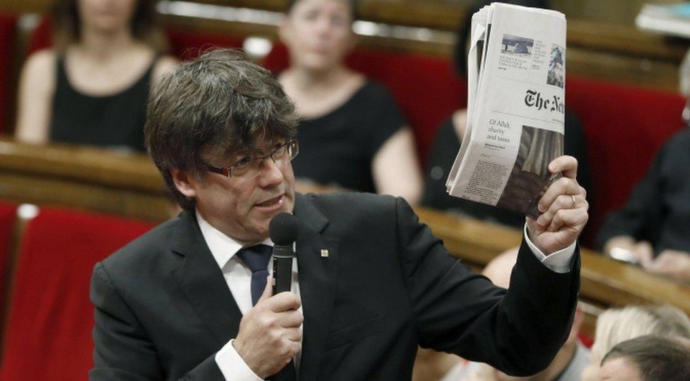 Spain's Catalonian regional president, Charles Puigdemont, holds an issue of the New York Times with an article on Catalonia's independence referendum, during question time at the regional Parliament in Barcelona, Spain, 28 June 2017.