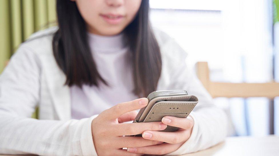 A stock photo of a girl using a phone