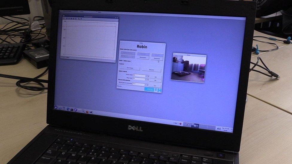 A laptop screen shows what Robin can see and his blood sugar levels