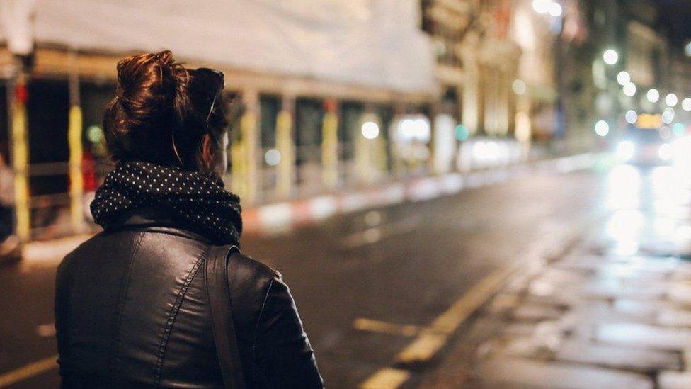 Woman walking down a road