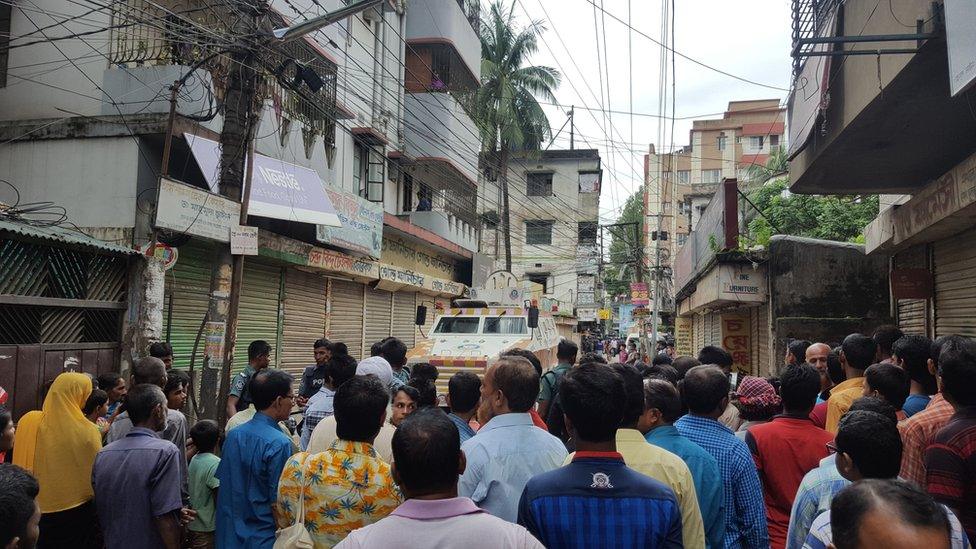 People gather near the scene of the police raid in Kalyanpur, Dhaka, Bangladesh, 26 July 2016