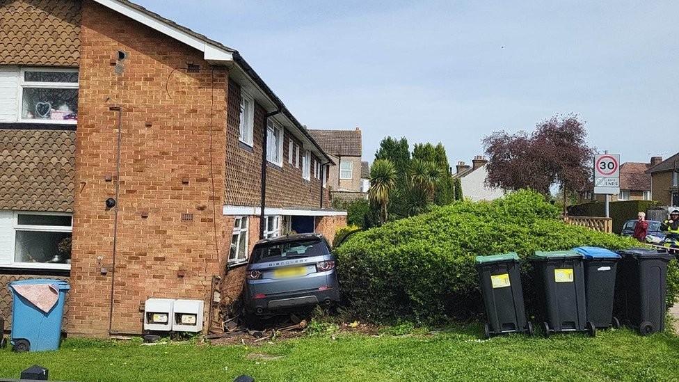 The car in the front of the house where it crashed into