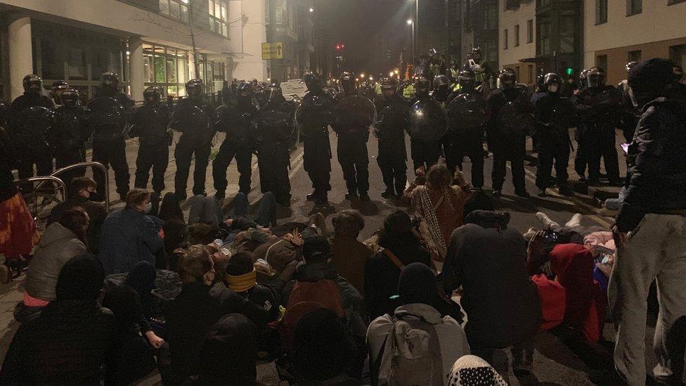 Police officers stand in position during a protest against new policing laws in Bristol