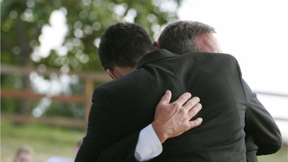 relatives hug at a funeral