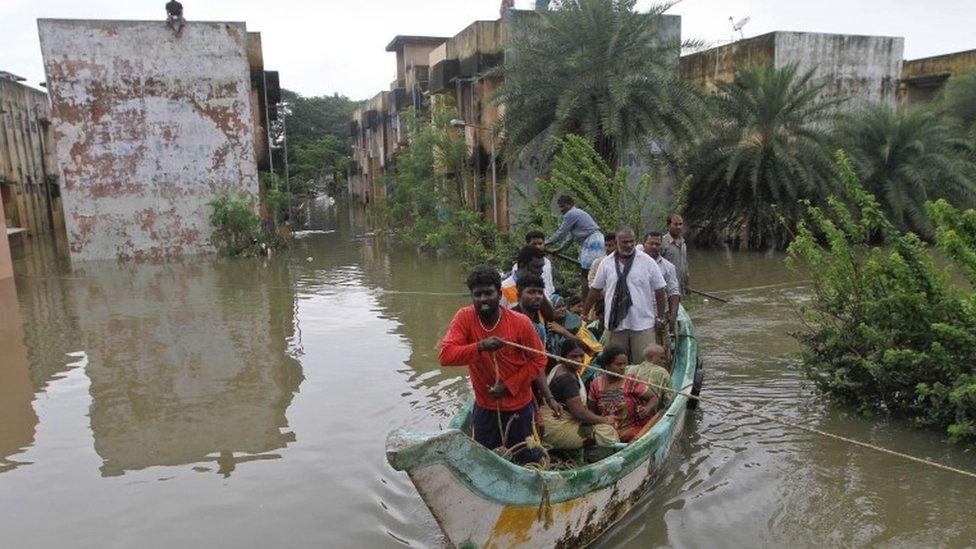 Volunteers rescue flood affected people on a country boat from a residential area in Chennai, India, Thursday, Dec. 3, 2015