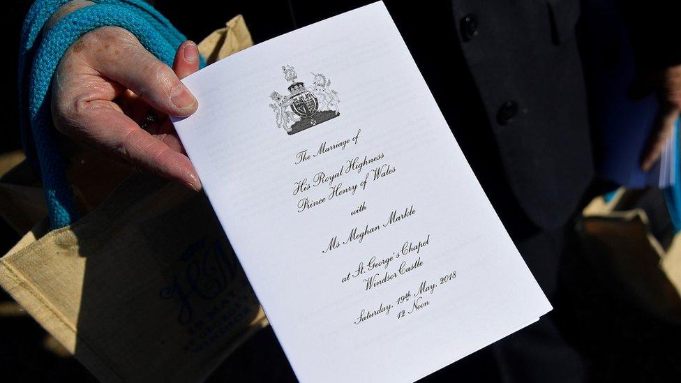 A member of staff holds an order of service inside the grounds of Windsor Castle