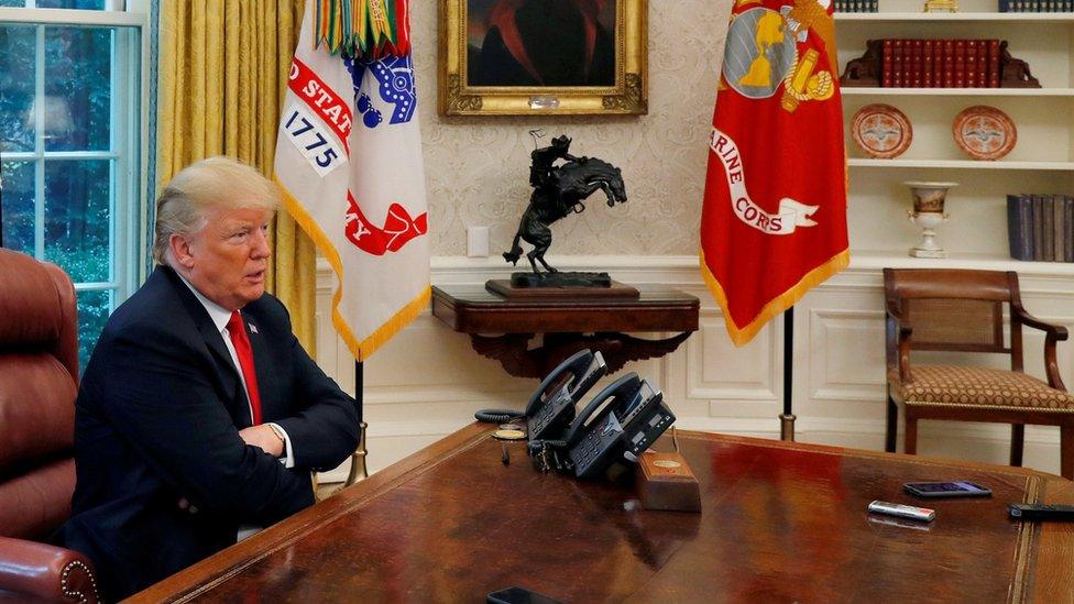 US President Donald Trump answers a reporter's question during an interview with Reuters in the Oval Office of the White House in Washington