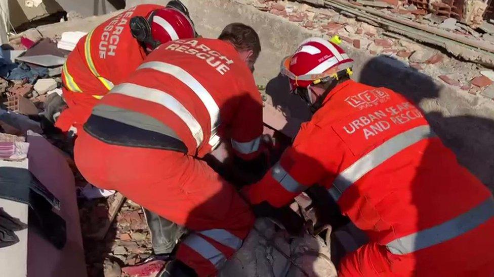 Firefighters searching for survivors in rubble