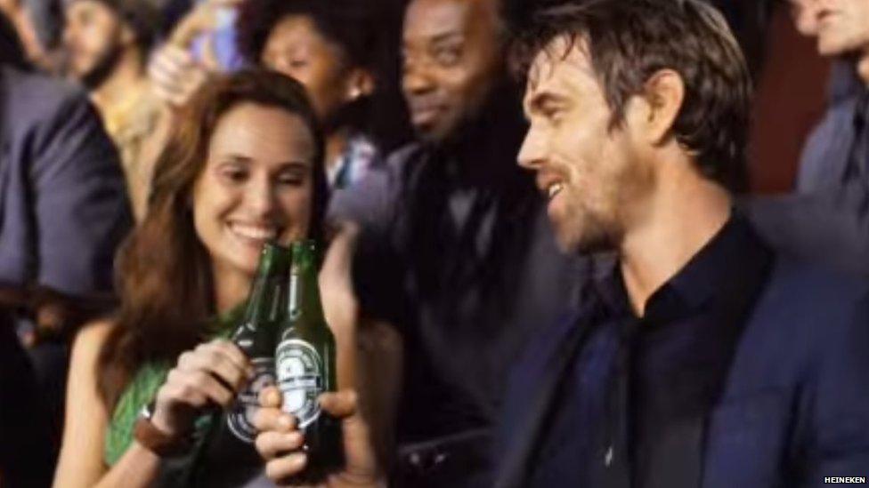 The Heineken advert shows a man and woman drinking in a football stadium