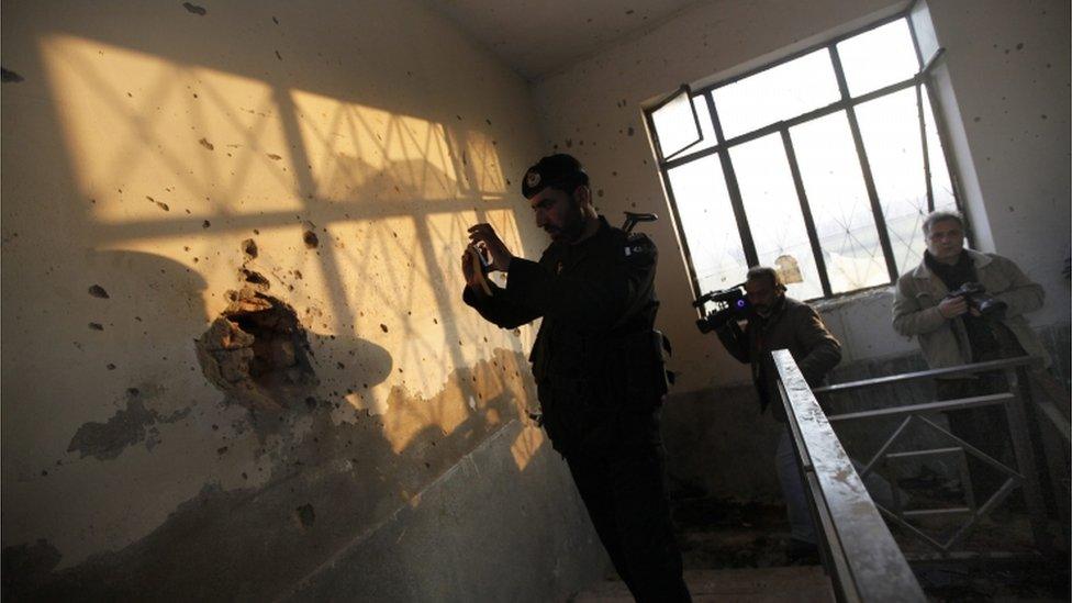 A Pakistani security official inspect the premises of Bacha Khan University